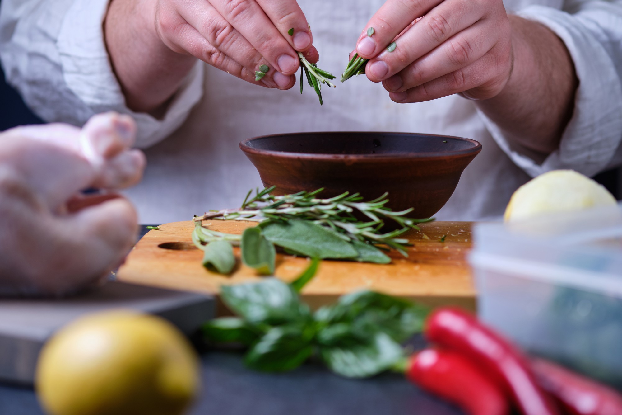 Chef arranging herbs in kitchen studio